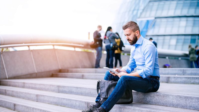 manager-with-tablet-sitting-on-stairs-london-city-PGB92TN